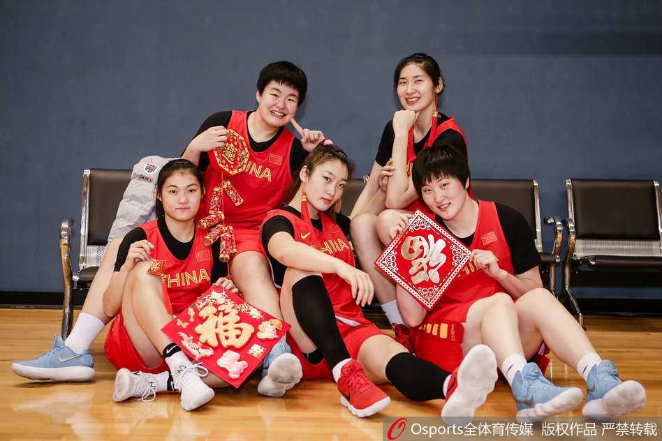 新春闪耀映红光,女篮精神铸辉煌 队长邵婷手持一张大大的福字,眼神中透露出坚定与温柔,身旁的队友们围绕着她,大家相互依偎,仿佛在传递着彼此的信任与对新一年赛场荣耀的共同期许。