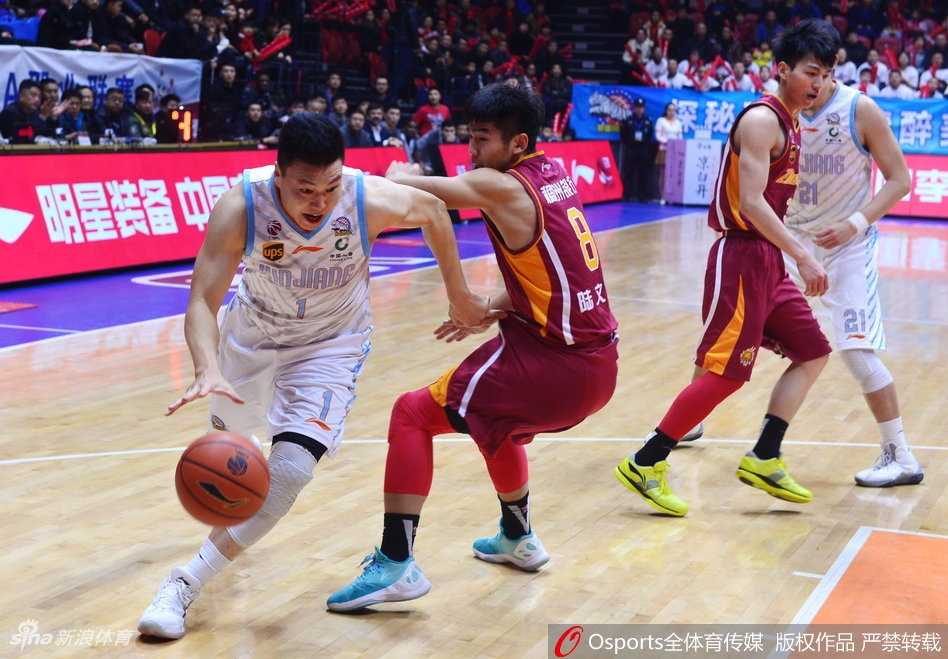 新疆队外援亚当斯在三人包夹下强行突破，他身形扭曲，脸上露出坚毅的表情，篮球仿佛黏在他手上一般，现场的焦点都聚集在他身上。