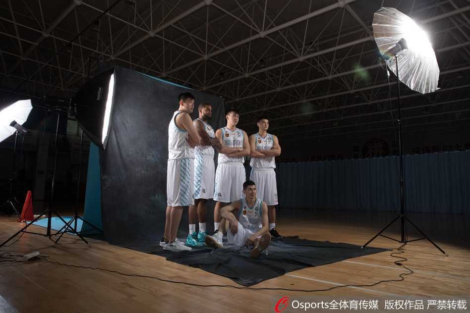 亚当斯在单人拍摄中摆出运球突破的姿态，身体重心压得极低，仿佛随时准备像离弦之箭般撕裂对手防线，嘴角挂着一丝自信的微笑。