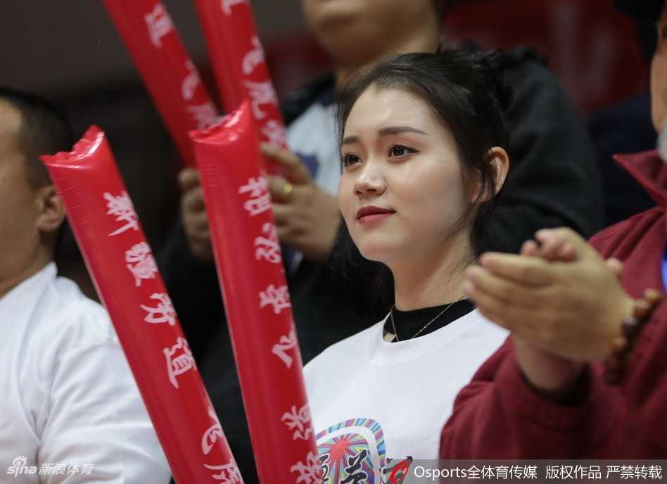 新疆男篮主场靓丽风景线 美女球迷激情助阵点燃红山 镜头捕捉到一位气质优雅的女球迷,她正用手机记录下赛场上的精彩瞬间,想要留住这一刻的美好。