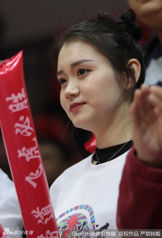 新疆男篮主场靓丽风景线 美女球迷激情助阵点燃红山 一位看起来年纪较小的学生球迷,穿着新疆队的队服,神情专注地为场上队员每一次精彩的配合鼓掌叫好。