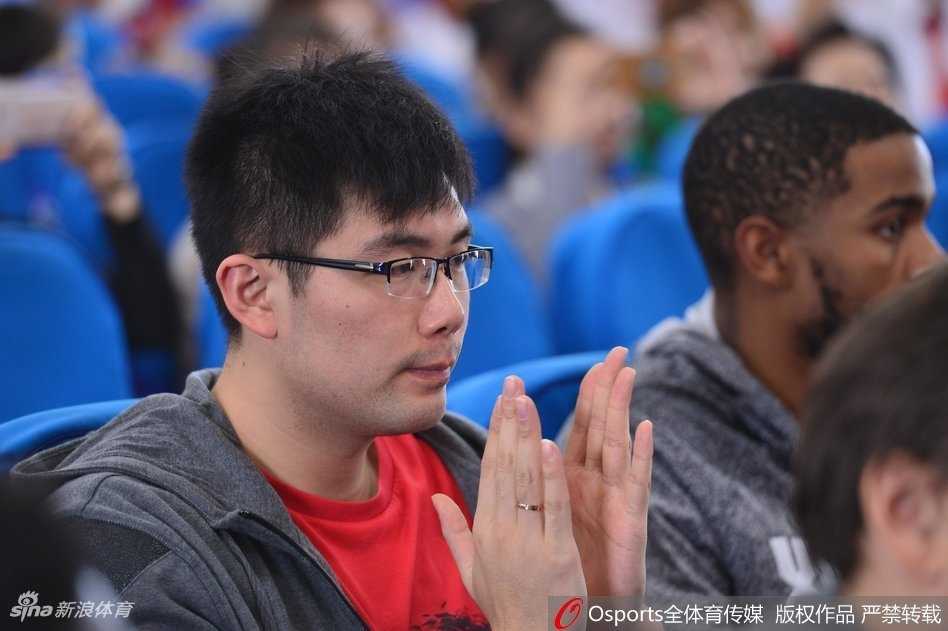 活动场边，一位聋哑学校的小球员紧紧抱着刚刚得到的签名篮球，他脸上挂着纯真的笑容，背景是正在和队友们交流的模糊球员身影，这一刻的快乐被永久定格。