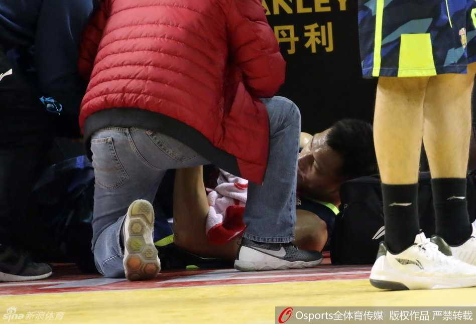 广东队队医神情专注地蹲在易建联身旁,一边询问伤处感觉,一边用双手小心翼翼地检查膝盖的肿胀和疼痛情况