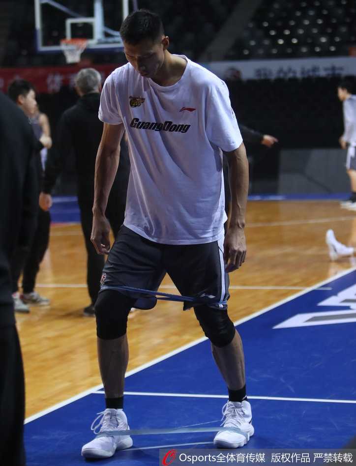 易建联在进行拉伸，身体舒展，肌肉线条流畅，展现了顶级运动员出色的身体柔韧性和协调性