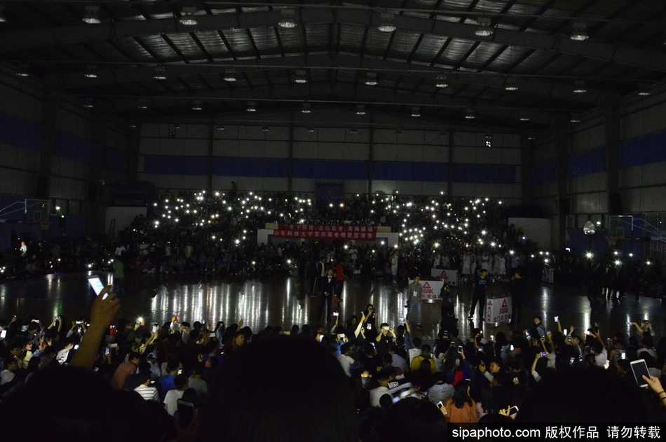 星夜下的全明星赛:山东科大停电瞬间,数千学子用手机点亮球场 几位学生肩并肩站在一起,同时举起手机,脸上带着灿烂的笑容,手机的光芒照亮了他们的脸庞和身后的黑暗