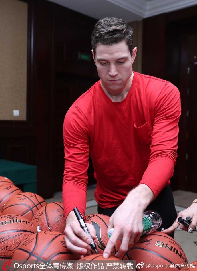 北方明星队的球员们围坐在长桌前，面对眼前成堆的签名需求，他们没有丝毫懈怠。镜头捕捉到一位球员正在台历上留下签名，背景里是队友方硕和翟晓川同样忙碌的身影，整个场景秩序井然又充满人情味。