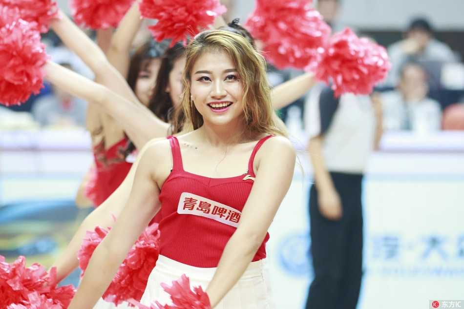 镜头拉近，这位扎着高马尾的啦啦队员眼神专注而明亮，手中的花球仿佛也被她的激情点燃，每一个动作都充满了力与美的张力