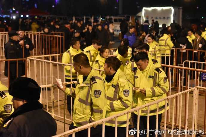 本溪公安消防齐助阵,辽篮主场大捷敬英雄 身着整齐制服的公安干警们在本溪体育馆看台就座,他们面带笑容,专注地观看比赛,身后的蓝色助威服球迷与他们形成鲜明对比,气氛热烈而和谐