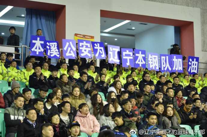 本溪公安消防齐助阵,辽篮主场大捷敬英雄 辽宁本钢队球员在赛前入场仪式中,韩德君表情轻松地与队友击掌,背景是看台上热情的本溪球迷和醒目的公益观赛团区域