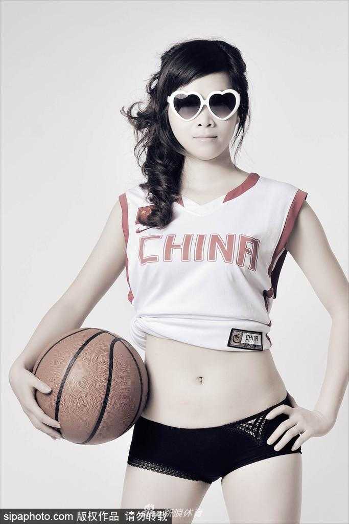 李怡侧身回眸，宽大的红白配色男篮球衣难掩其窈窕身姿，心形眼镜反射出点点光芒，整体画面动感十足。