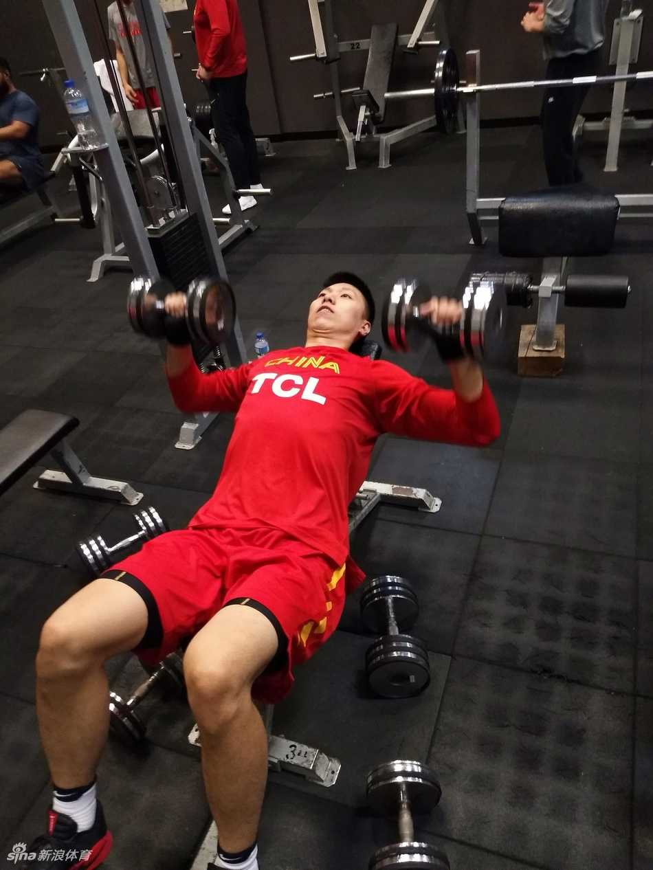 队长周鹏双手持哑铃进行力量训练，坚实的臂膀和专注的神情，彰显着作为一名领袖在队中以身作则的榜样力量。