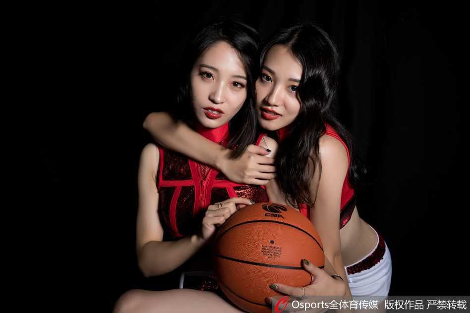 镜头特写捕捉到宝贝的侧颜与精致的锁骨线条，黑色的羽毛头饰与朦胧的背景灯光交织，营造出一种既柔美又充满张力的舞台剧氛围