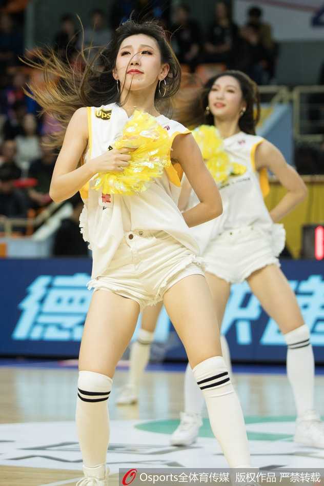 浙江广厦主场大胜天津 篮球宝贝热舞点燃赛场 另一位篮球宝贝在表演中甩动秀发,手中的花球如同跳跃的精灵。她身穿亮片短裙,动作舒展而充满力量,展现出当代CBA篮球宝贝专业、自信的职业素养。