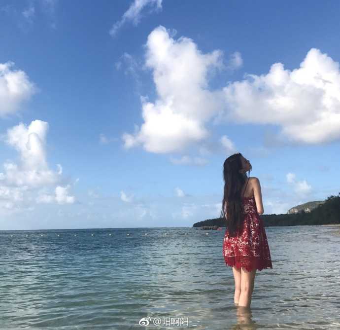 马阳阳漫步在细软的沙滩上，身后是蔚蓝无际的大海，她随意撩动秀发的瞬间被镜头定格，充满了自然随性的动态美感。