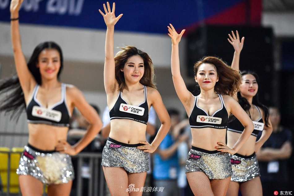 湘中明珠的篮球盛宴:新疆男篮大胜之夜,篮球宝贝热舞点燃郴州赛场 拉拉队员们围成一个小圈,中心一位队员做出高难度的空中劈叉动作,周围的队友们纷纷伸出双手给予保护,展现了团队之间的信任与默契