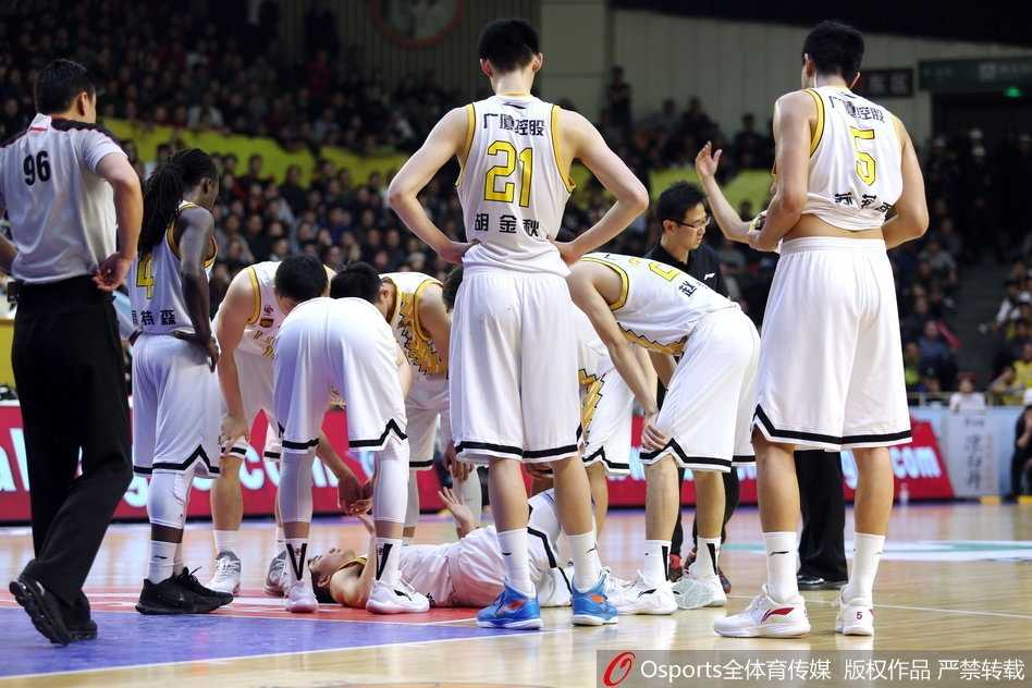 孙铭徽在拼抢后痛苦倒地，双手紧捂脚踝，面部因剧痛而扭曲，身旁的队友和对手都露出关切而紧张的神情