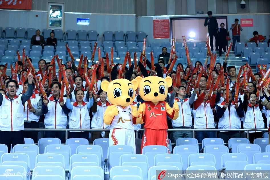 火箭精神燃情看台:八一男篮吉祥物与球迷的难忘互动 吉祥物俯身逗弄看台上的小朋友,它用毛茸茸的手掌轻轻抚摸孩子的头,周围的家长纷纷举起手机记录下这暖心一刻,整个看台区域洋溢着欢乐的气氛