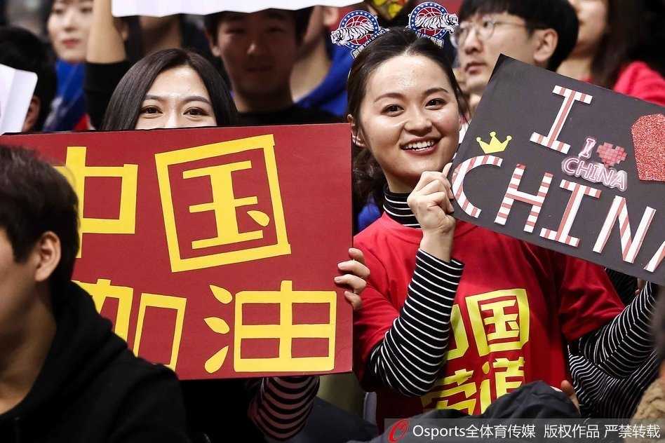 热血与颜值齐飞:篮球架下那道最美的风景线 这位长发披肩的女生神情专注地看着场内方向,手中的加油牌上写着鼓舞人心的语句,她安静而坚定的姿态宛如赛场边一道宁静而有力的风景,默默为球员输送着精神力量。