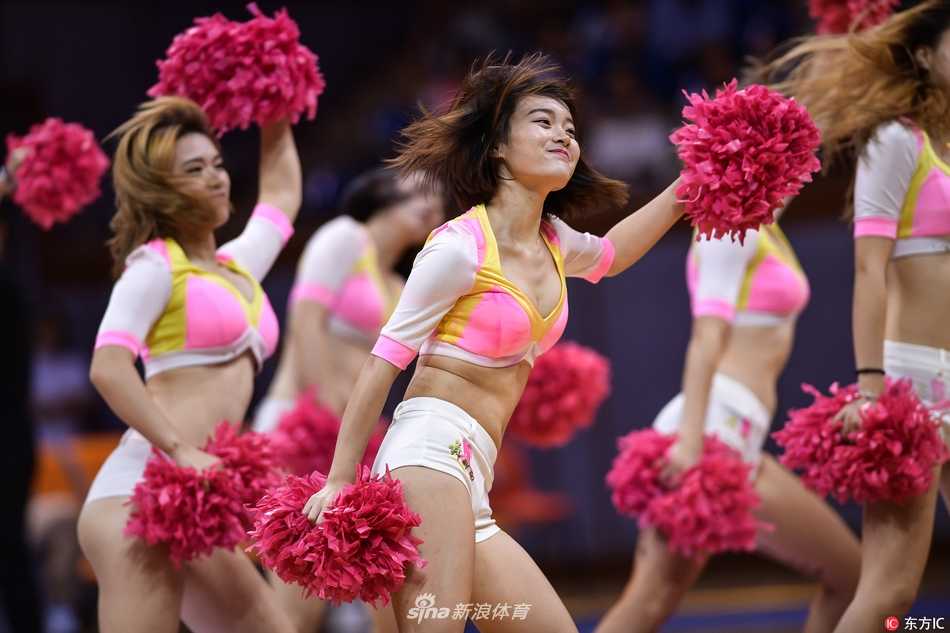 热裤热舞点燃赛场:CBA啦啦宝贝的青春与热爱 镜头聚焦于一位正在热舞的啦啦队员,她上身白色紧身衣勾勒出优美的线条,下身蓝色热裤格外亮眼。她面带自信的微笑,正随着音乐节奏摆动手臂,身后的队友们形成了整齐的队列。