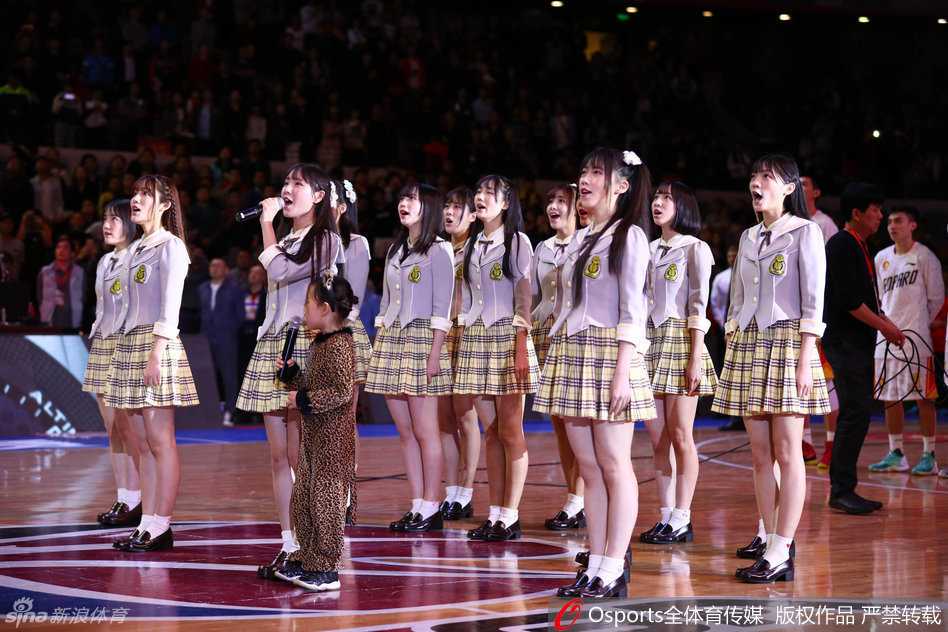 镜头拉近，一位GNZ48成员对着镜头俏皮地比出剪刀手，身后的篮球架与她的青春活力构成了一幅热血又可爱的画卷。