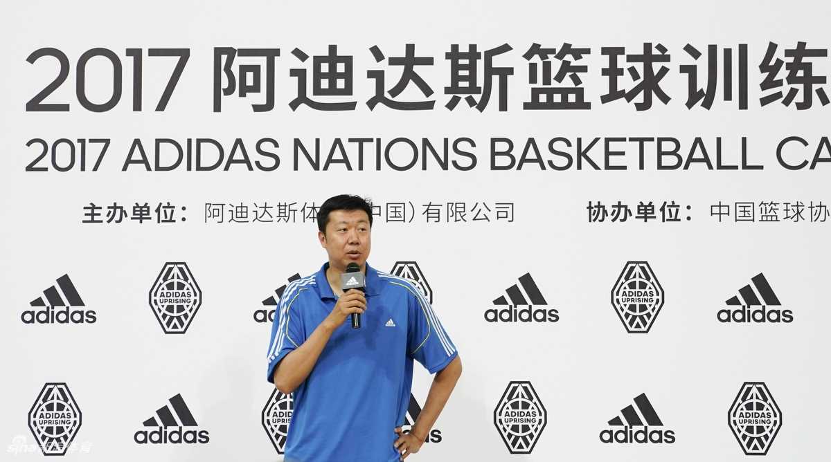 王治郅与刘晓宇的薪火相传:从八一传奇到青训守望者 训练营的小球员们分组对抗,王治郅在场边叉腰观战,身后是醒目的阿迪达斯标志