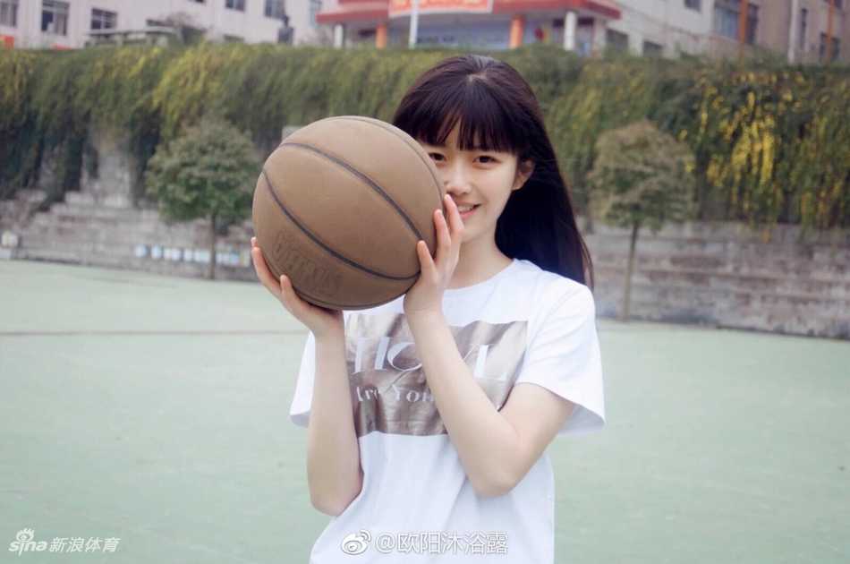 欧阳沐浴露扎着清爽马尾，身穿红色篮球背心，在球场边回头一笑，眼神清澈明亮，充满了少女的纯真与活力。