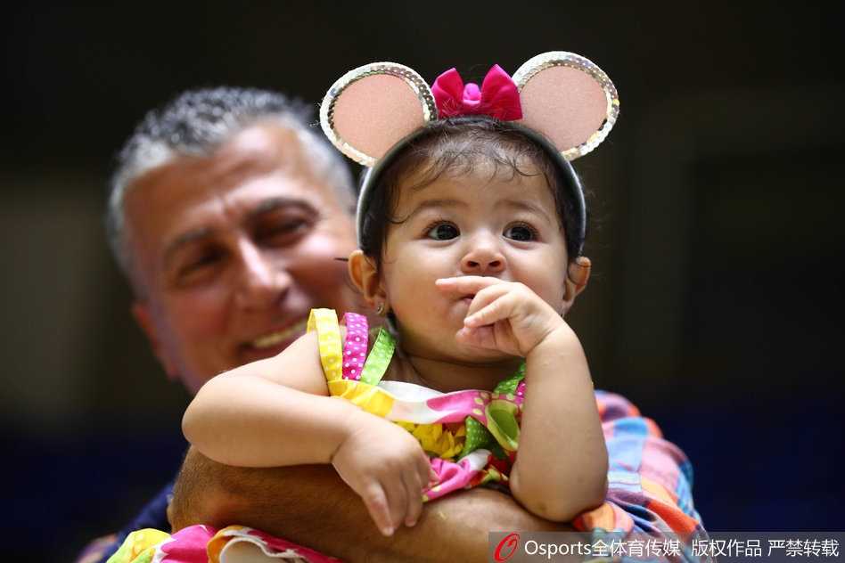 几名中国球迷高擎五星红旗，目光紧紧跟随比赛，旗帜如火焰般耀眼