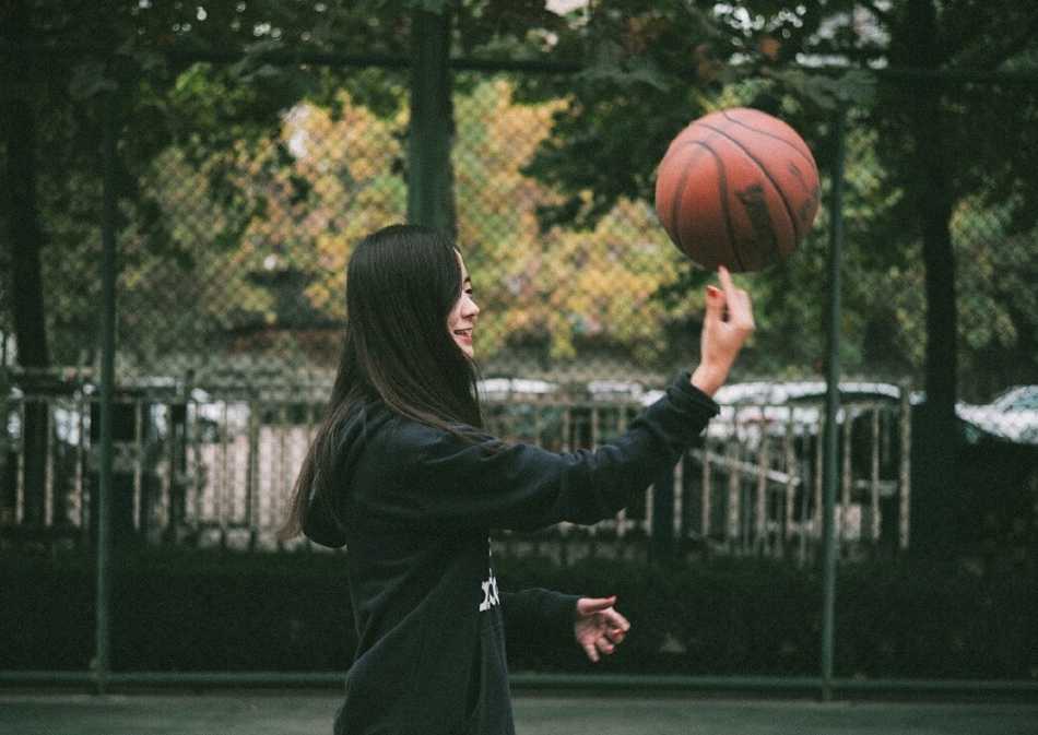 夕阳余晖下，孙夕雨扎着清爽马尾，身穿骑士队球衣，对着镜头露出甜美又自信的微笑，身后是安静的篮球场。