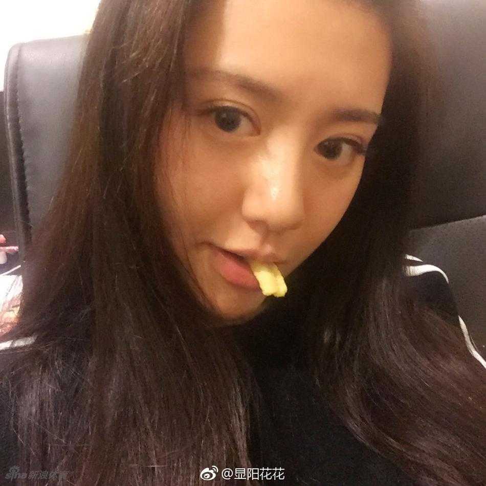 女神在球场背景前露出自信从容的微笑，肤白胜雪，笑容灿烂，一双大长腿在宽松的牛仔裤下依然难掩其修长优势，整体造型清新又时尚。