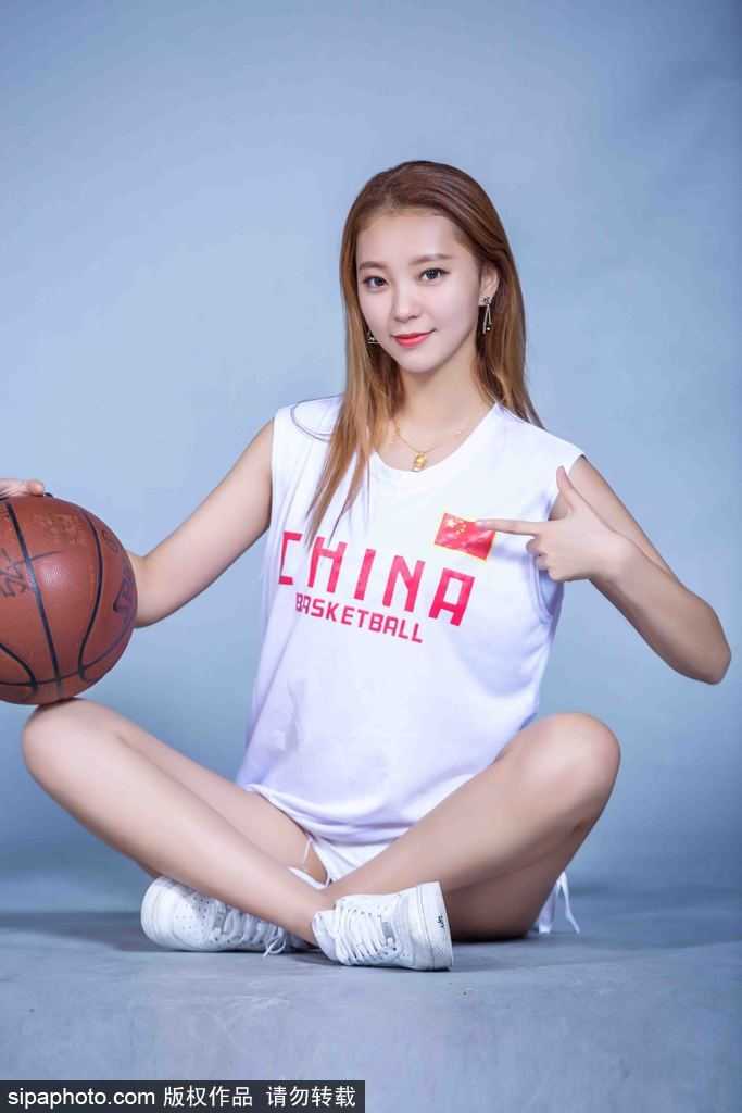 特写镜头下，篮球宝贝轻咬嘴唇，头戴个性棒球帽，白皙手臂自然垂落，神态俏皮中带着一丝不羁，充满青春的故事感。