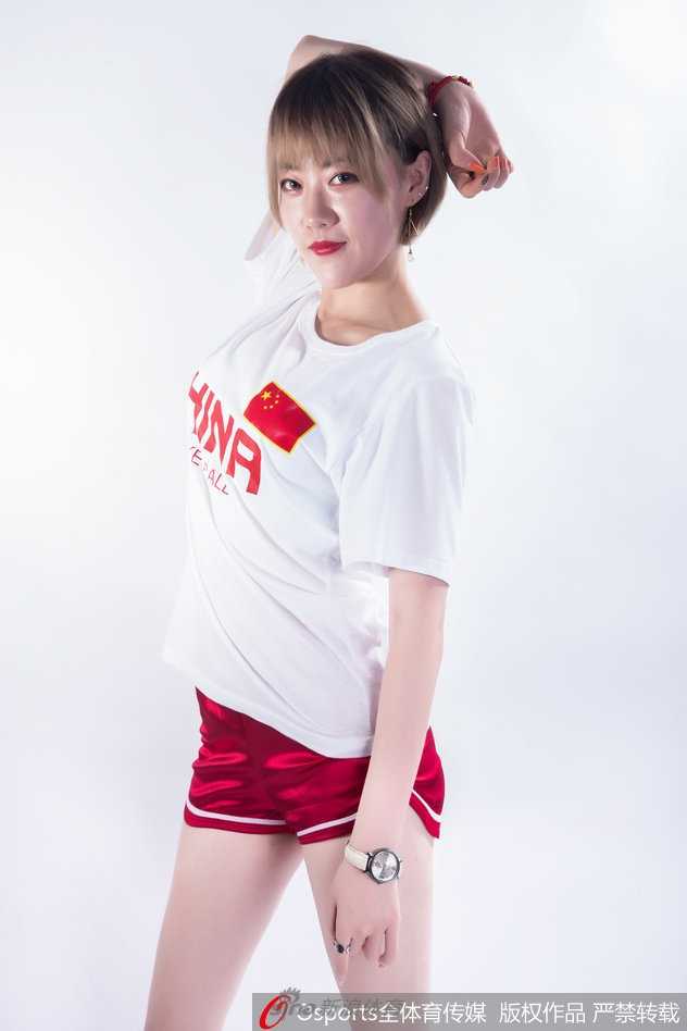 写真拍摄现场，一位篮球宝贝坐在地板上，回眸瞬间露出温柔可爱的笑容