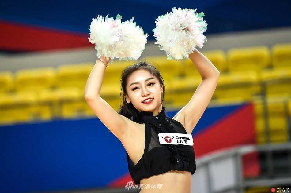 一位篮球宝贝在表演中回眸凝视镜头，眼神中透露出专业舞者的专注与灵动，金色的小彩球在她手中仿佛有了生命，随着指尖飞舞。