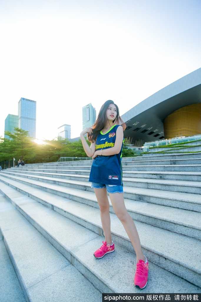 篮球宝贝青春助威,广东队主场喜迎新赛季开门红 一位篮球宝贝双手指向镜头,神情俏皮又充满自信,身后的队友身影虚化,突显出她个人独特的青春魅力。