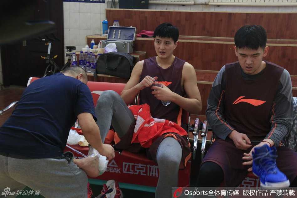 训练结束后，李根在场边被热情的球迷簇拥。他俯身在新疆队围巾和球衣上认真签名，脸上挂着随和的笑容，耐心满足着每一个支持者的愿望。