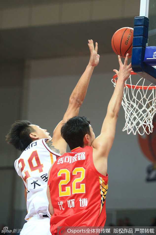 孙喆在篮下遭遇对手凶狠侵犯，巨大的身躯失去平衡，但他在倒地瞬间依然试图将球控制在手中，展现了内线悍将的执着。