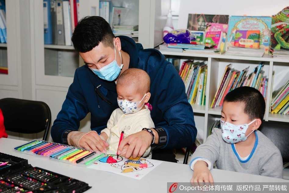翟晓川张松涛与白血病儿童共绘温暖篮球梦 翟晓川盘腿坐在地板上,与几个戴着口罩的小朋友围成一圈,他正拿着一个彩色气球逗其中一个孩子,孩子们咯咯笑着伸手去够,场面温馨如同一个大哥哥带着弟弟妹妹做游戏