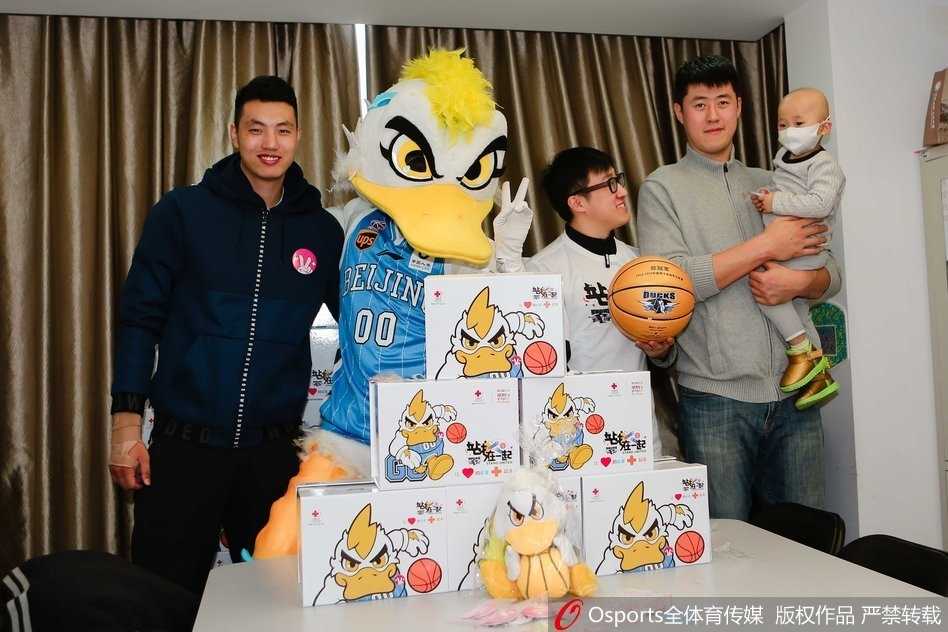 翟晓川张松涛与白血病儿童共绘温暖篮球梦 身穿红色队服的翟晓川和张松涛半蹲在病床前,手里拿着彩色画笔,正温柔地与戴着口罩的小朋友一起涂鸦,病床上的小桌板成了临时的画桌,孩子的眼神专注而明亮