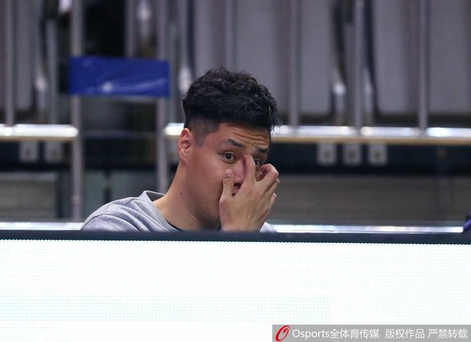 贺天举手搭毛巾表情轻松，在替补席上与队友谈笑风生