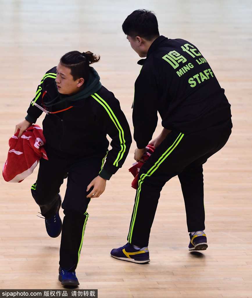 “擦地哥”孟飞双膝跪地，双手紧握白色毛巾飞速擦拭地板，专注的眼神中透露出对这份志愿工作的极致认真与热爱