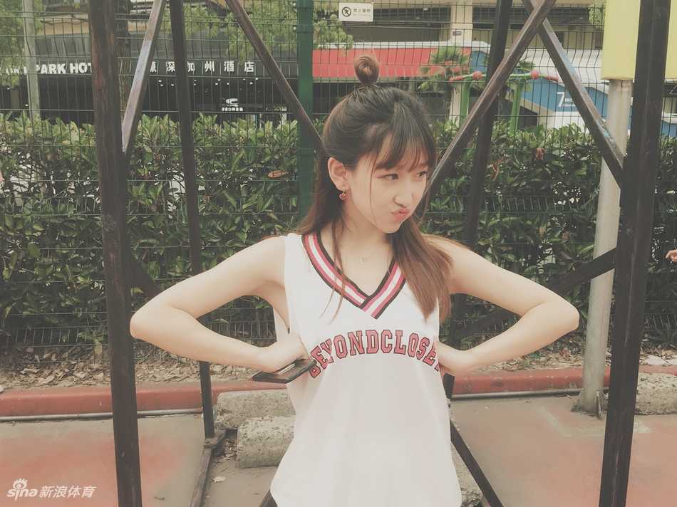 小娜与队友们摆出可爱的造型合影，她俏皮的表情和纤细的身材在人群中格外醒目