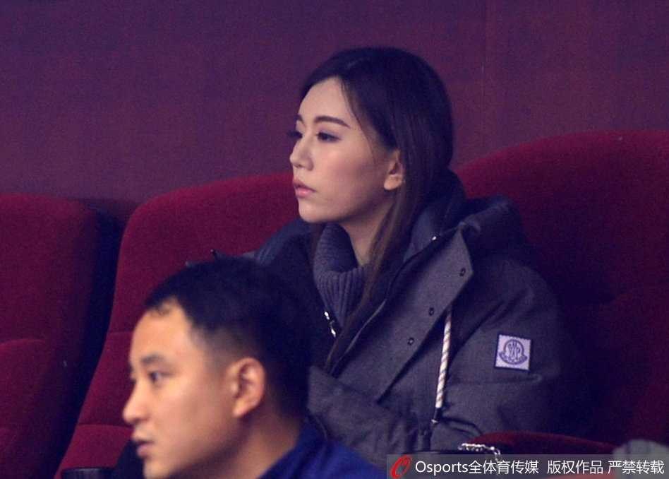 赛场灯光映照下，她抿紧嘴唇，双手安静地放在膝上，那份专注仿佛凝固了时间，完全沉浸在与场上球员同频共振的紧张节奏里。