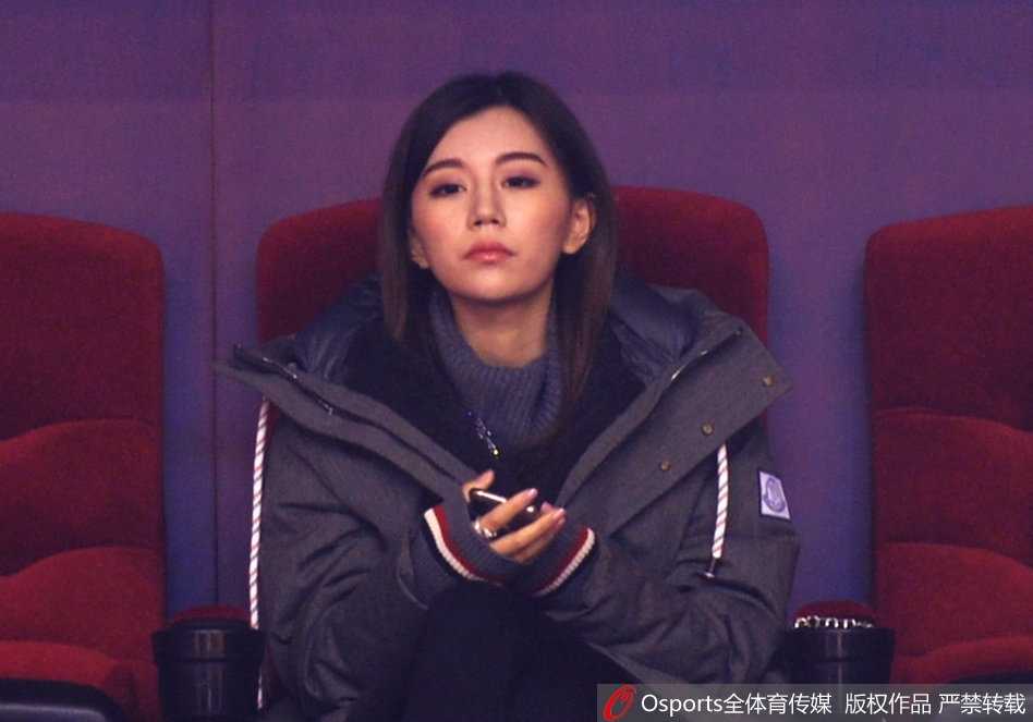 随着比赛进行，她时而轻咬手指，眼神中流露出一丝不易察觉的担忧，仿佛场上每一次激烈的身体对抗，都让她感同身受。