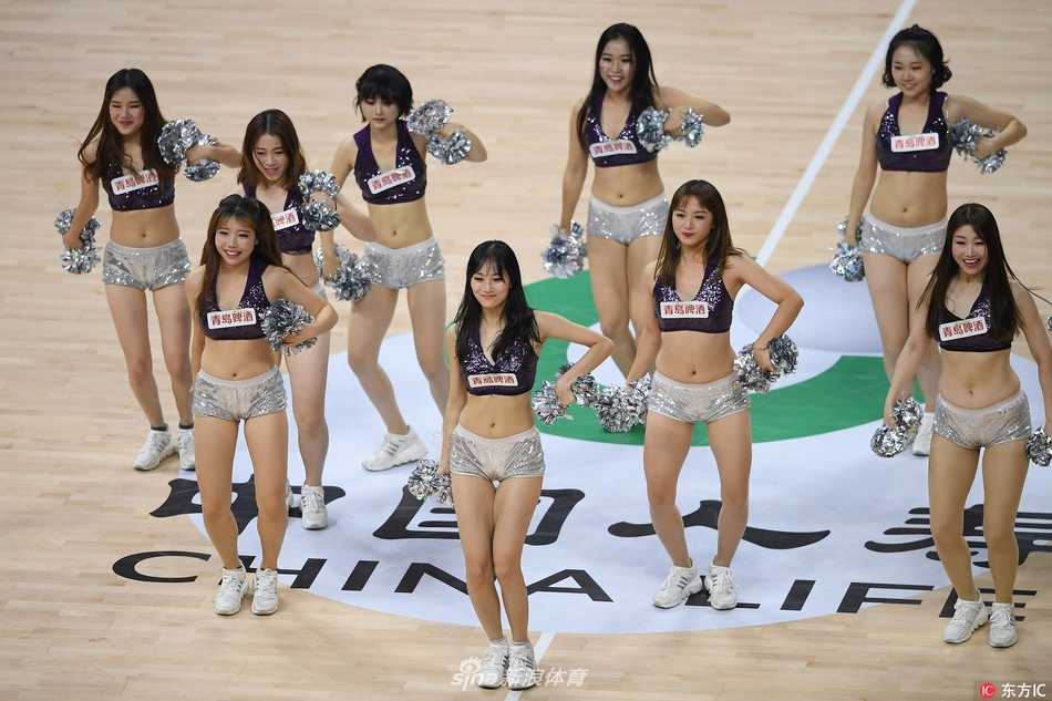 比赛间隙，几位啦啦宝贝在场地角落迅速整理着装，互相帮忙检查服装细节，场上的光鲜亮丽离不开后台这些默契而温馨的互助瞬间。