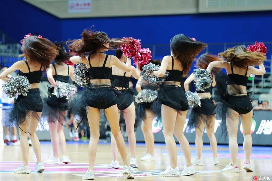 几名拉拉队员围在一起，赤足站在场边，轻松的氛围中透露出团队的默契。她们修长的腿部线条自然舒展，为紧张的赛场增添了一抹温柔的亮色。