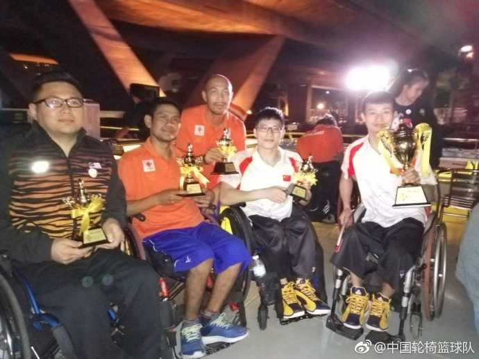 轮椅上的逆转之王:广东省轮椅篮球队亚残预选赛勇夺桂冠 面对身材高大的防守球员,中国队队员眼神坚毅,他一手控制疾驰的轮椅,一手稳稳将球传向篮下的队友,轮椅的轮毂在灯光下折射出拼搏的光芒。