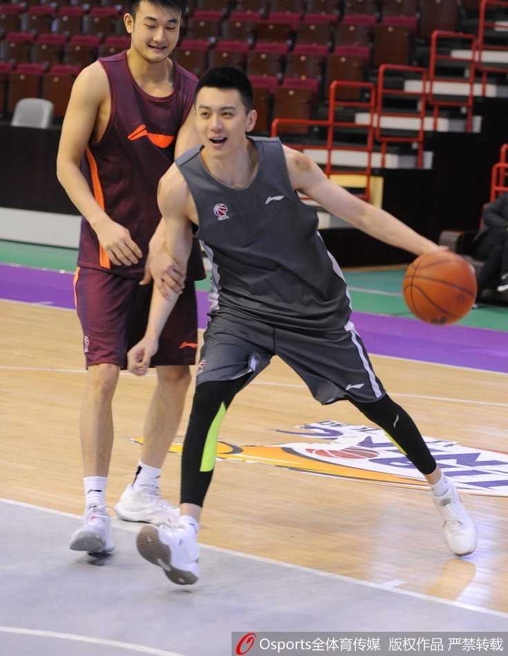 杰特身穿训练服，在与巴斯交流时神情专注，嘴角带着微笑，仿佛在分享什么球场趣事。