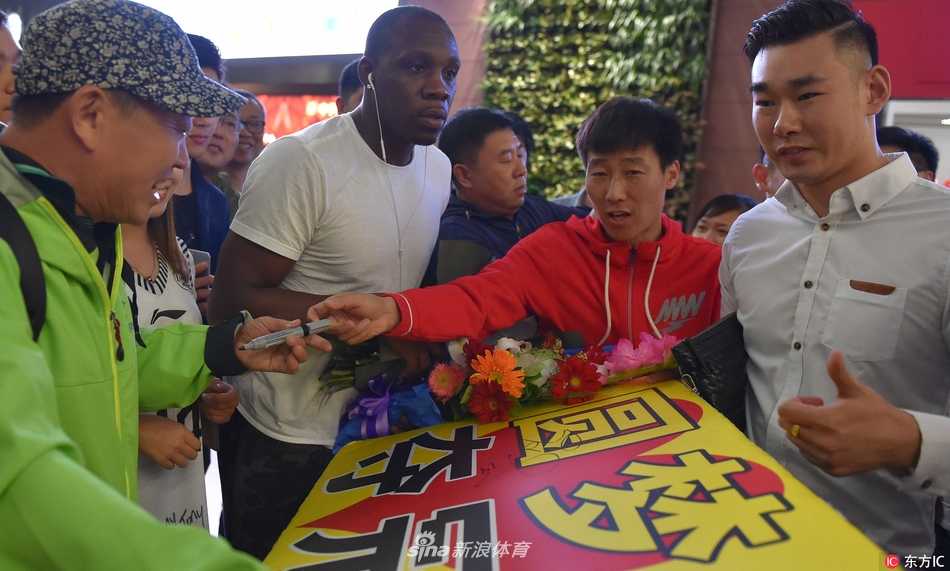辽篮功勋荣归故里 哈德森抵沈开启冲冠新征程 哈德森被热情的接机人群团团围住,他低头为几位幸运的球迷签名,闪光灯将他的脸庞照得格外清晰,仿佛定格了这荣耀的一刻。