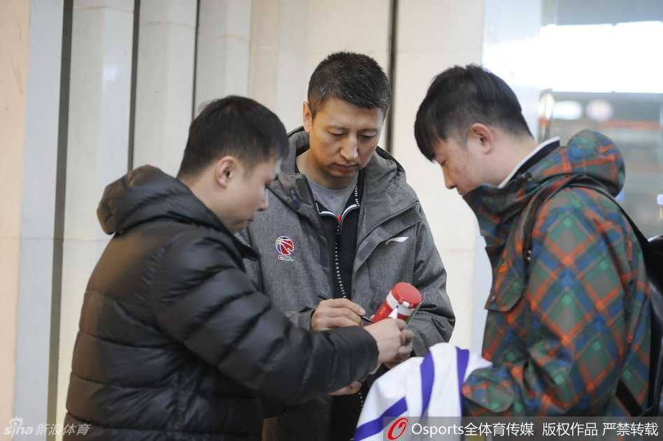 辽篮启程客场受热捧 郭艾伦韩德君人气无上限 主教练郭士强被几位老球迷围住,他双手递回签好名的战术本,眼角的笑纹透露出对这份支持的感动