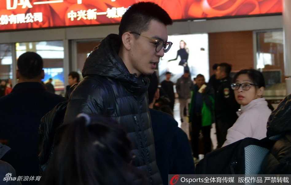 辽篮队员走出通道，瞬间被热情的球迷包围，闪光灯和欢呼声此起彼伏，郭艾伦面带微笑向支持者们挥手致意。