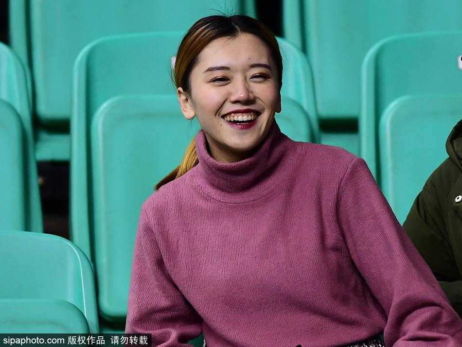 一位面容清秀的女球迷坐在看台上，她身着黑色外套，专注地看着场内，眼神中透露出对辽篮的关切与期待，仿佛下一秒就要为心爱的球队呐喊。